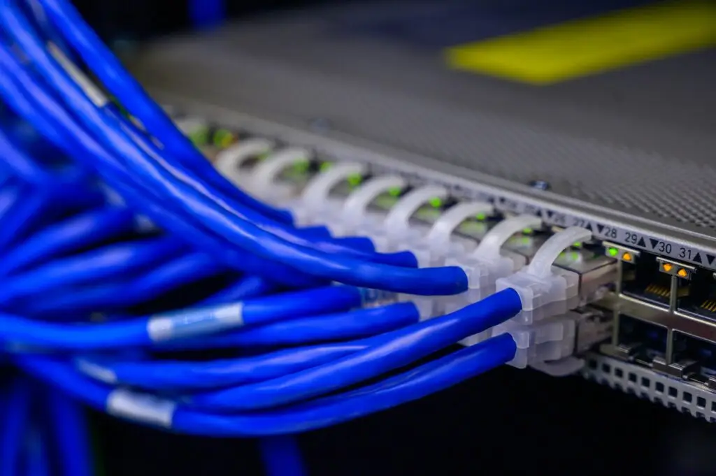 CAT5 Data cables plugged into network switch. Structured data cabling and patching in a comms rack. Structured cabling in York and Harrogate